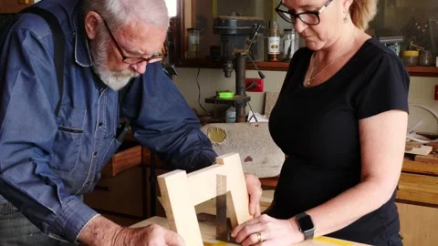 Woodwork marking measuring squaring timber older gentleman and lady assistan Stock Footage 231892113