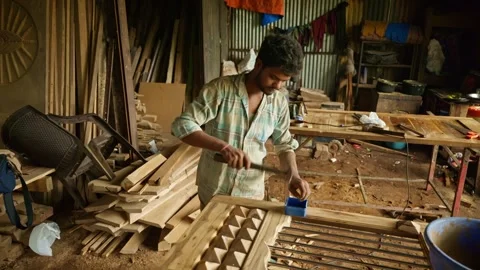 Woodworker assembles tiny timber shapes upon door frame 動画素材 313667085