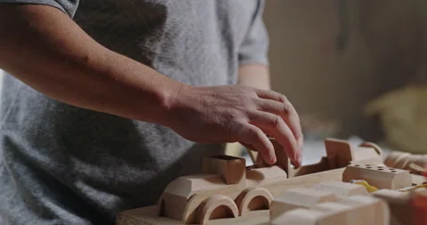 Woodworker assembling toy train in workshop. Crop unrecognizable craftsman Stock Footage 148553995
