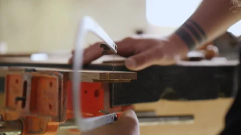 A woodworker cuts out a dovetail joint on an oak plank with a hand jigsaw.han Stock Footage 144244569