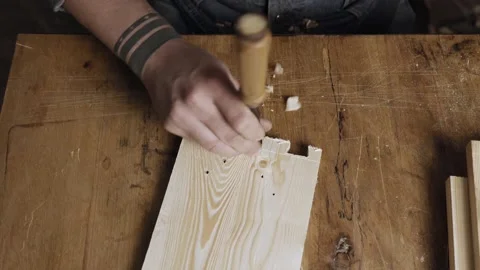 A woodworker cuts out a dovetail on a pine board with a chisel. dovetail join Stock Footage 166341023