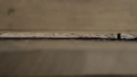 A woodworker is cutting an old walnut plank with a hand-held electric fraser. Stock Footage 137149914