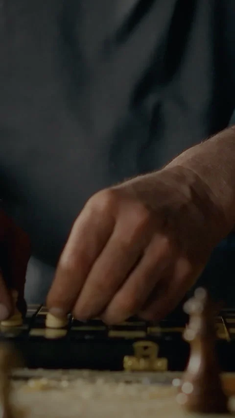 Woodworker engaging in strategic thinking while holding chess pieces in work Stock Footage 331739949
