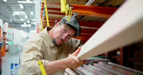 Woodworker Inspects Lumber in Hardware Store Aisle Stock Footage 323787502
