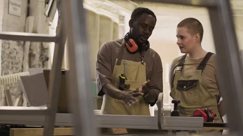 Woodworker Instructing Young Female Apprentice in Carpentry Workshop 動画素材 292788098