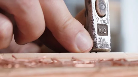 Woodworker, male worker using a hammer hammers a nail into wooden board, close Stock Footage 246902959