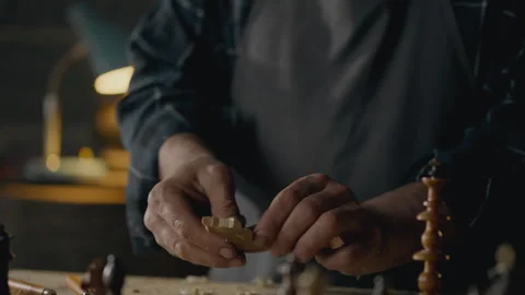 Woodworker, middle-aged In progress Examining the result of carving chess pi Stock Footage 243007630