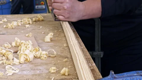 Woodworker planing a board in workshop Видео 337552225