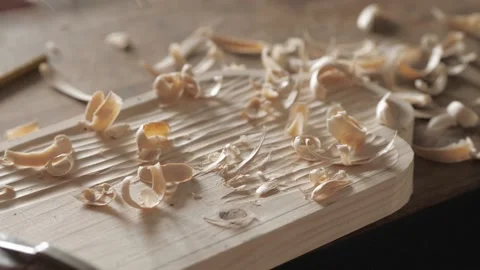 A woodworker processes a pine wood board with a chisel. artisan makes a tea tray Stock Footage 156670516