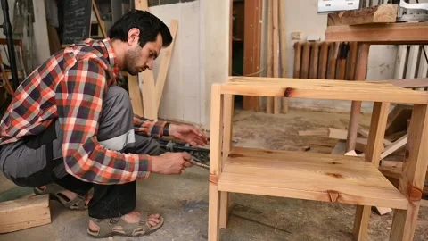 Woodworker puts varnish on a wooden table. Stock Footage