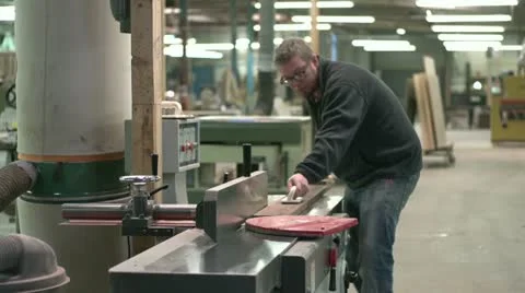 Woodworker putting board through a jointer Stock Footage 11016570