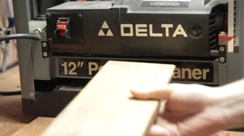 Woodworker putting board through a planer Stock Footage 42234470