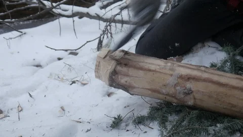 Woodworker sharpening end of log with axe in wilderness during winter Stock Footage 121220142
