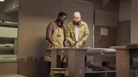 Woodworker Showing Apprentice How to Polish Wooden Board with Electric Sander 動画素材 292789440