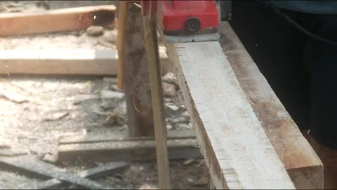 A woodworker uses an electric planer to smooth the surface of a wooden Stock Footage 333345370