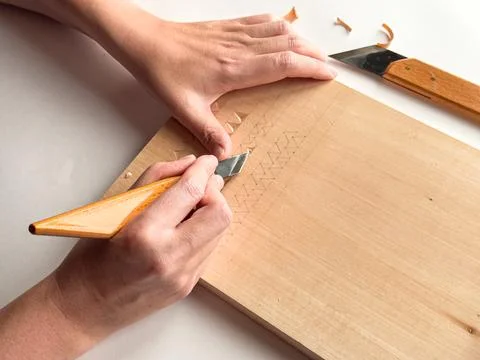 Woodworking craftsmanship. Precision carving techniques on wooden surface Stock Photos