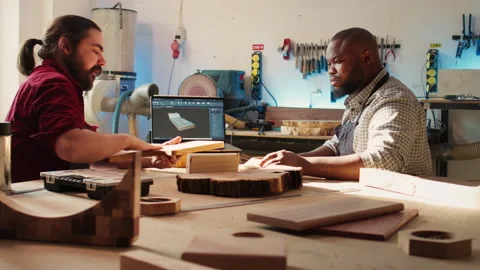 Woodworking experts in studio crosschecking wooden object with blueprint Stock-Footage 271097516