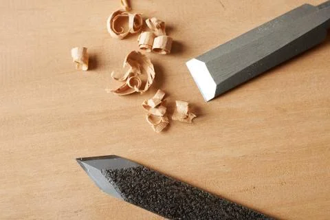 Woodworking tool. Chisel and marking knife with shavings on workbench. Stock Photos