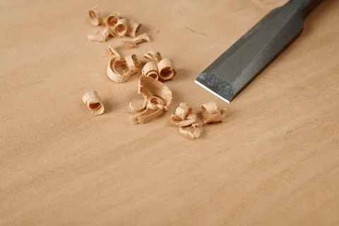Woodworking tool. A chisel with shavings on workbench. Stock Photos
