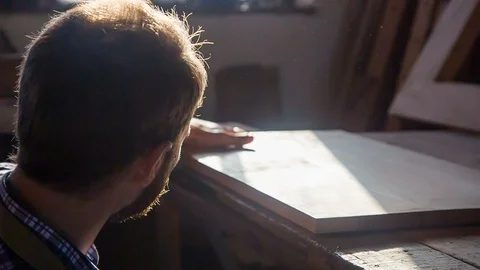 The woodworking wizard examines the quality of the coating by touch. RAW video Stockbeeldmateriaal 89775126