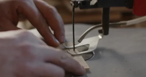 Woodworking at the workshop: carpenter uses automatic jigsaw and cuts small Stock Footage 149759033