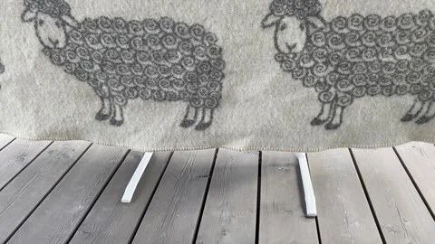 Wool blanket with sheep pattern on wood surface Видео 343864516