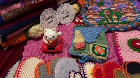 Wool gloves and maneki neko on the shelves at the flea market : 4K footage Stock Footage 70019799