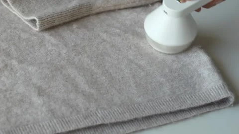 Wool sweater placed on surface prepared for fabric care routine. Textile Stock Footage 331864914