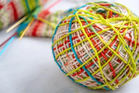 Wool yarn in foreground with knitting project behind Stock Photos
