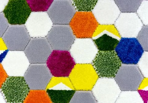 Woolen carpet with a pattern in the form of multi-colored honeycombs. Stock Photos