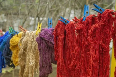 Woolen colorful threads are hanging on a clothesline with clothespins outdoor Stock Photos