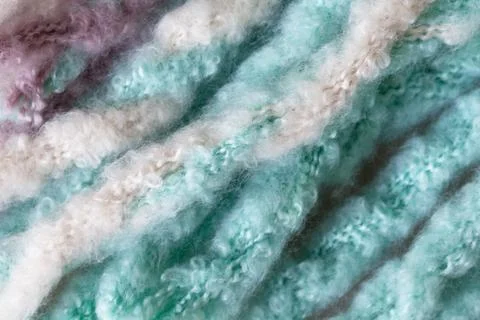Woolen fluffy threads or tassels from scarf, macro. Soft pastel colors Foto stock