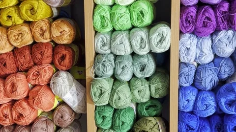 Woolen threads of different colors in the store on the shelf. Vertical video Video stock 250114270