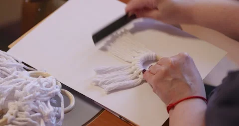 A wooman crafts handcrafted gift elf figurines. She combing at cotton yarn. Stock Footage 274866370