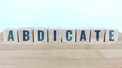 Word abdicate written with wood cubes on table Stock Photos