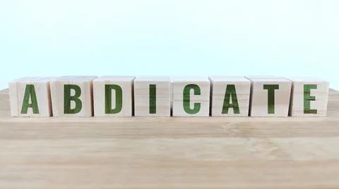 Word abdicate written with wood cubes on table Stock Photos