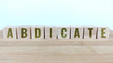 Word abdicate written with wood cubes on table Stock Photos