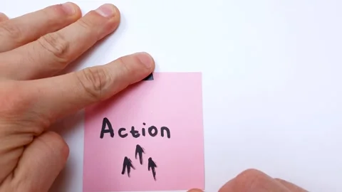 The word ACTION is written on a sticky note with an arrow on a white background Stock Footage 315395161