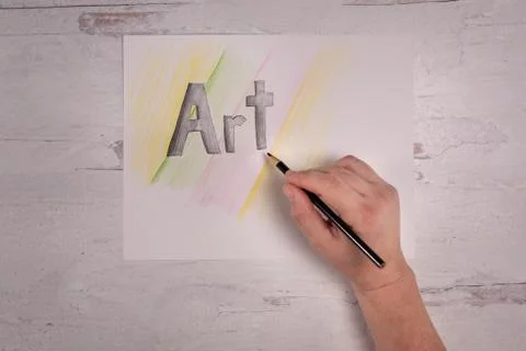 The word ART sketched on drawing paper with colorful backing real hand Stock Photos