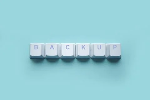 Word BACKUP written on computer keyboard keys isolated on a turquoise Stock Photos