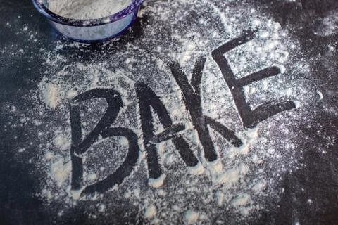 The word bake drawn into flour dusted on tabletop Stock Photos