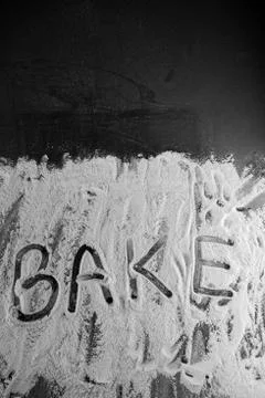 Word bake written in flour on table Stock Photos