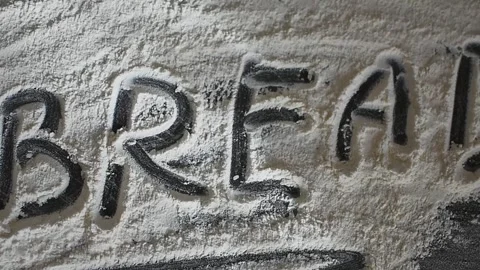 The word "bread" is painted with flour scattered on a black table Stock Footage 306340718