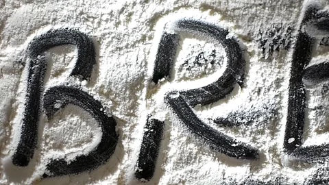 The word "bread" is painted with flour scattered on a black table Stock Footage 306340721