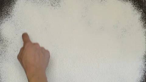 Word BREAD is written on white flour. Finger scanning BREAD on flour. The Stock Footage 125252374