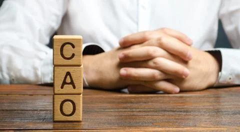 The word CAO and a man with locked hands. Chief Accounting Officer. Vacancy.. Stock Photos