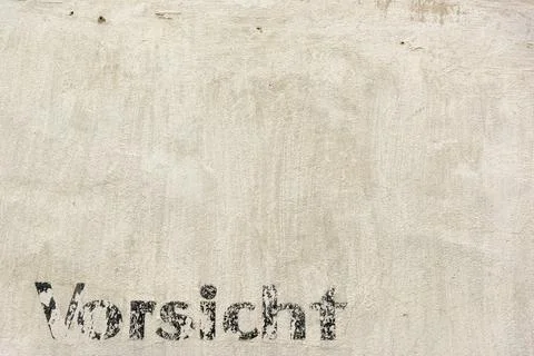 The word caution in german language on a facade Stock Photos