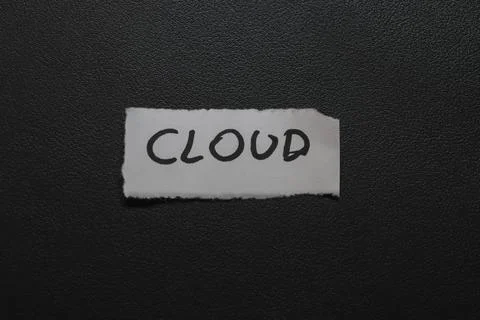 The word CLOUD handwritten on a piece of white paper, contrasting against a dark Foto stock