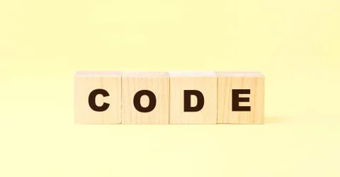 Word code on small wooden blocks against yellow background 스톡 사진