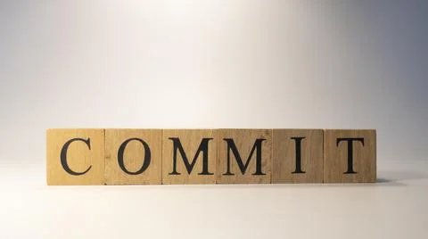 The word Commit was created from wooden cubes.Close-up. Stock Photos
